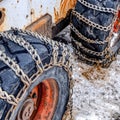 Square Old and rusty bulldozer with heavy duty black wheels wrapped in metal chains