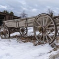 Square An old wooden wagon on a rocky terrain covered with snow in winter Royalty Free Stock Photo