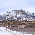 Square Panoramic view of an immense mountain dusted with snow against a cloudy sky