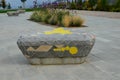 Square in the park with benches in the shape of round triangles lined with tiles in the shape of an irregular mosaic with colored