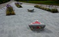 Square in the park with benches in the shape of round triangles lined with tiles in the shape of an irregular mosaic with colored