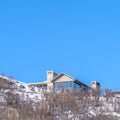 Square Park City Utah mountain scenery in winter with homes against blue sky background