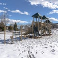 Square Park playground amid footprints on sunlit snow covering the ground in winter Royalty Free Stock Photo