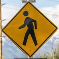 Square Pedestrian Crossing sign Crosswalk lights and Diagonal Arrow sign beside a road Royalty Free Stock Photo