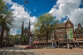 Square with people, church and typical buildings in Amsterdam.