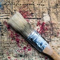 Square photo of an one inch brush on wooden workbench stained grunge textured surface Royalty Free Stock Photo