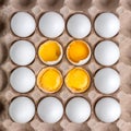 Square photo of raw chicken eggs on recyclable cardboard tray, one broken with yolk on the top, paper packaging pattern with copy