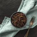 A square photo of wild black rice, shot from the top on a black background with a fork Royalty Free Stock Photo