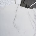 Workspace with keyboard notebook, mouse and copy space on marble table. Royalty Free Stock Photo