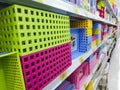 Square plastic storage baskets of various colors on the shelf in a chain store