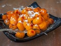 A square plate with frozen sea buckthorn berries for a light dessert, stands on a woodentable Royalty Free Stock Photo