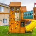 Square Playground structure with slide swings playhouse tower and climbing wall Royalty Free Stock Photo