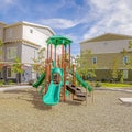 Square Playground surrounded by a circular pathway and benches under cloudy blue sky