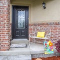 Square Porch with bench of a home with glass paned door and concrete and brick wall
