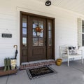 Square Porch of a house with bench and wooden rack with boots and umbrella