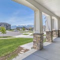 Square Porch with pillars and a combination of concrete and stone brick exterior walls