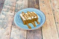 square portion of carrot cake with pieces of dried fruit on top and drizzled with dulce de leche syrup Royalty Free Stock Photo