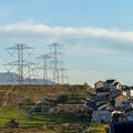 Square Power lines towering over neighborhood and roads in the valley on a sunny day Royalty Free Stock Photo