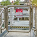 Square Private Dock No Trespassing sign on a metal gate against canal in Long Beach CA Royalty Free Stock Photo