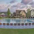 Square Puffy clouds at sunset Large community pool at Daybreak, Utah with lounge chairs and cl