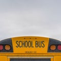 Square Rear of a yellow school bus with signal lights and emergency exit window Royalty Free Stock Photo