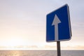 Square road sign with white arrow on blue sky background. Royalty Free Stock Photo