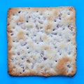 Square salted cracker on blue background. Royalty Free Stock Photo