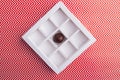 Square-shaped chocolate box with one single candy. Royalty Free Stock Photo