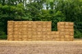 Square shaped hay bales stacked in a wall on harvested wheat field, drying on summer sun. Royalty Free Stock Photo