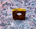 A square shaped nutbolt standing on a rough textured brick concrete background Royalty Free Stock Photo