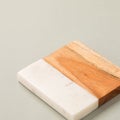 Square shaped-wooden cutting board with white marble texture on a grey background Royalty Free Stock Photo