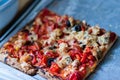 Square slice of pizza on a gray tin tray