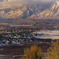 Square Snowy Mount Timpanogos and charming homes against cloudy blue sky at sunset