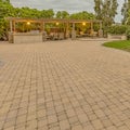 Square Stone brick driveway and patio with fire pit and dining area under a pavilion Royalty Free Stock Photo