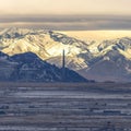 Square Sweeping view of Salt Lake City bordered by towering sunlit snowy mountain