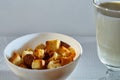 Square toasted pieces of homemade delicious rusk, hardtack, Dryasdust, zwieback and glass of milk on a white tablecloth