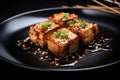 square tofu steak pieces floating in teriyaki sauce