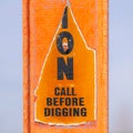 Square A torn Caution sign on a bright orange post against a blurry background