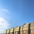 Square Townhouses with brick wood and concrete wall against blue sky on a sunny day