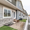 Square Townhouses exterior view with grassy backyards enclosed in low picket fences