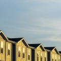 Square Townhouses on a neighborhood under blue sky and clouds on a sunny day