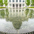 Square Utah State Capital Building reflected at the clear water of a circular pool