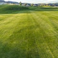 Square Vibrant fairway of a golf course with homes and mountain in the distance Royalty Free Stock Photo