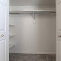 Square Walk in closet with double hinged doors plain white wall and gray floor carpet