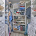 Square Walk in closet interior with white wooden shelving units