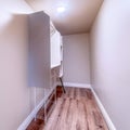 Square Walk in closet with metal rod and shelves on the wall mounted white cabinet