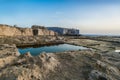 Square water reservoir on the rocky sea coast, Gozo.