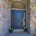 Square Whispy white clouds Entrance exterior of a house with black door with lockbox, arched transom window, and side Royalty Free Stock Photo