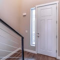 Square White hinged wooden front door and sidelight viewed from inside of home