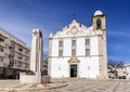 Square with white church and monument in Olhao, Portugal